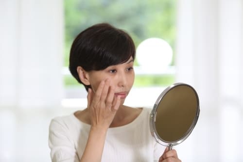 クマが気になり悩む女性